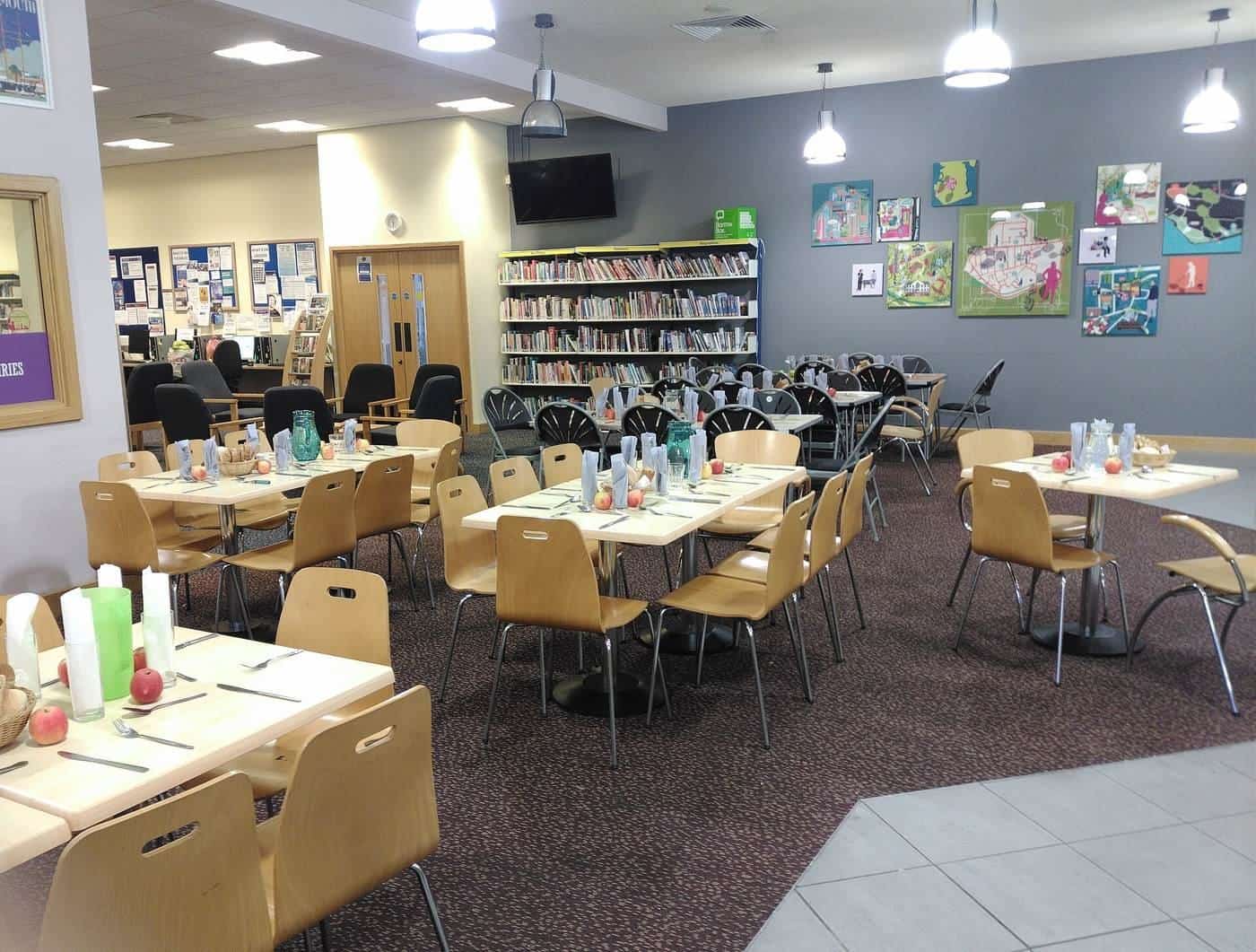 A large room set up with tables for a shared meal